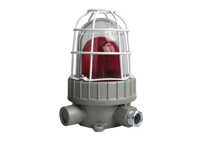 Industrial explosion-proof red warning light with a protective white wire cage and a heavy-duty grey metal base for emergency signaling.